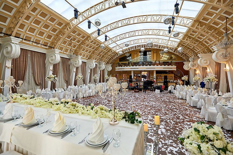 Банкетный зал «Триумф» Расстановка столов свадебного банкета с молодоженами в центре. Сьемка с балкона